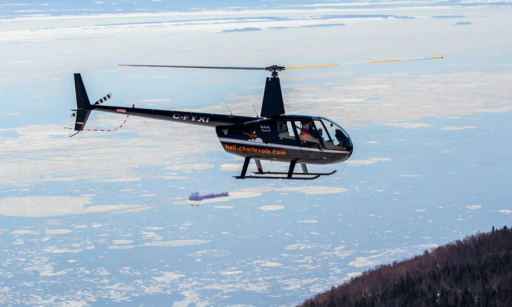 un hélicoptère de héli charlevoix au dessus du fleuve